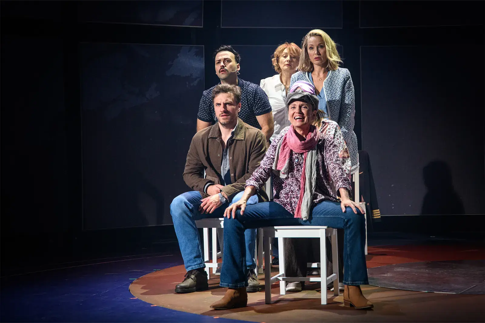 Scena z polskiego musicalu Come From Away z aktorami w teatralnym oświetleniu